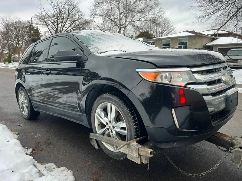 North York scrap car pickup: vehicle secured to a tow truck for removal